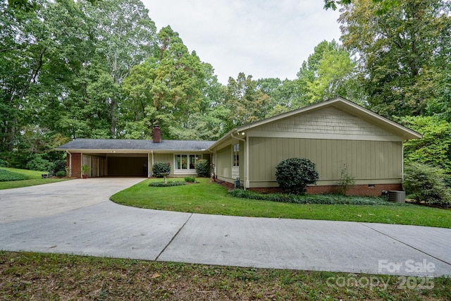 ranch-style home featuring a carport, cooling unit, and a front yard