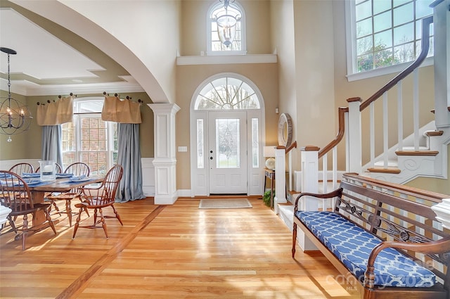 entrance foyer featuring plenty of natural light, a towering ceiling, and a notable chandelier