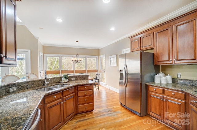 kitchen with ornamental molding, appliances with stainless steel finishes, decorative light fixtures, and dark stone countertops