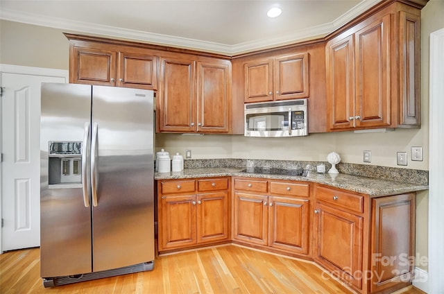 kitchen with light hardwood / wood-style flooring, ornamental molding, stainless steel appliances, and stone countertops