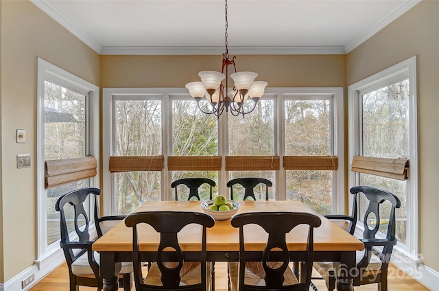 dining space with a healthy amount of sunlight, ornamental molding, and a chandelier