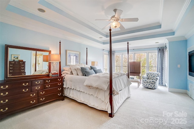 carpeted bedroom with a raised ceiling, crown molding, and ceiling fan