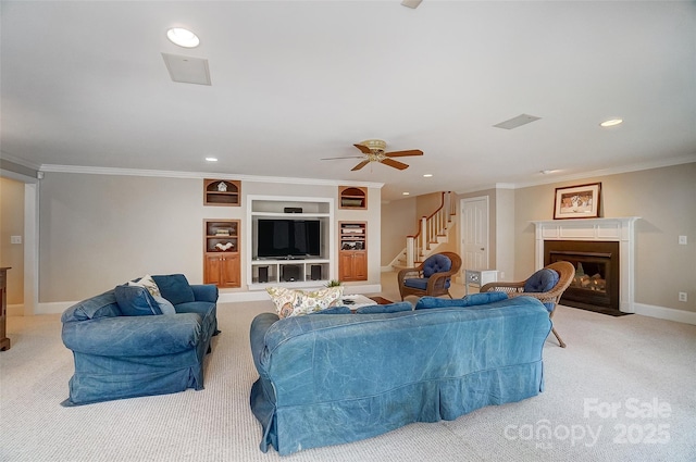 carpeted living room featuring ornamental molding, built in features, and ceiling fan