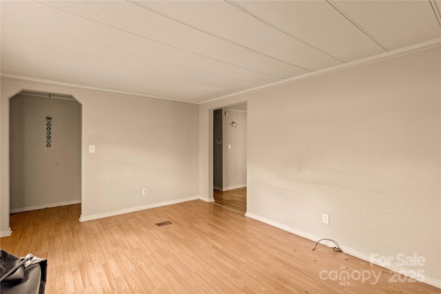 spare room featuring hardwood / wood-style floors and crown molding