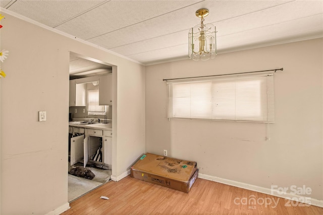 interior space featuring wood-type flooring, ornamental molding, and sink