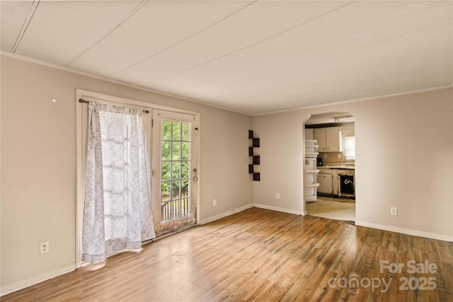 spare room featuring light hardwood / wood-style floors and ornamental molding