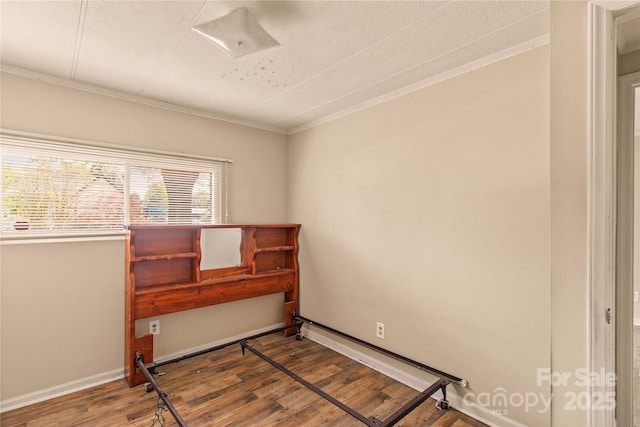 empty room with hardwood / wood-style flooring and ornamental molding