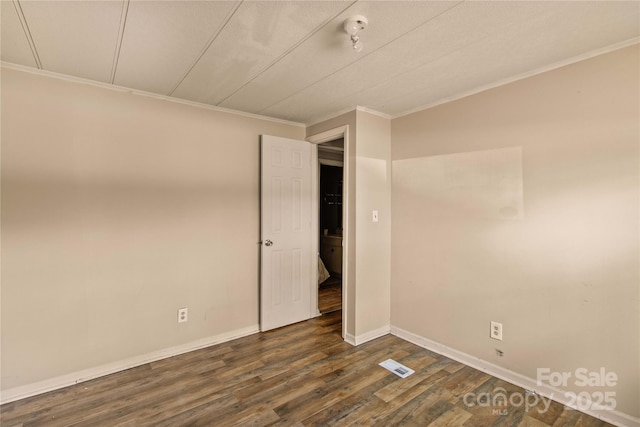 empty room with dark hardwood / wood-style floors and ornamental molding