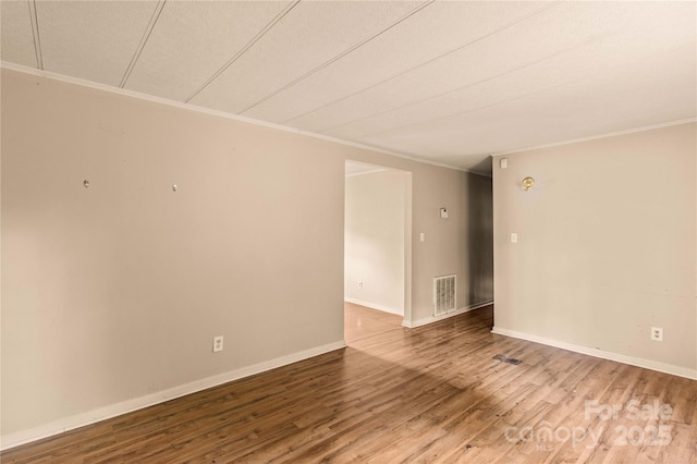 unfurnished room with wood-type flooring and ornamental molding