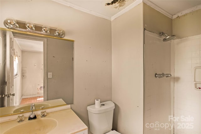 bathroom with a shower, crown molding, vanity, and toilet