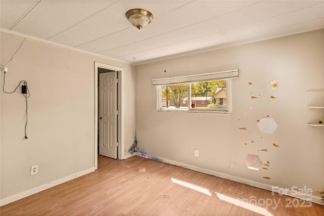 empty room featuring light hardwood / wood-style floors and ornamental molding