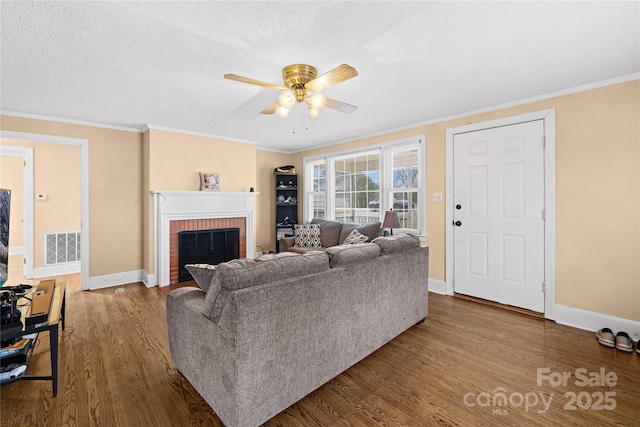 living room featuring a brick fireplace, ceiling fan, crown molding, and hardwood / wood-style floors