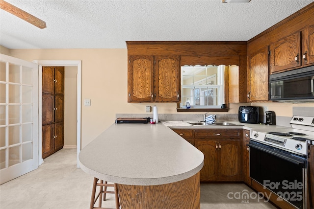 kitchen with sink, a textured ceiling, a kitchen breakfast bar, kitchen peninsula, and range with electric stovetop