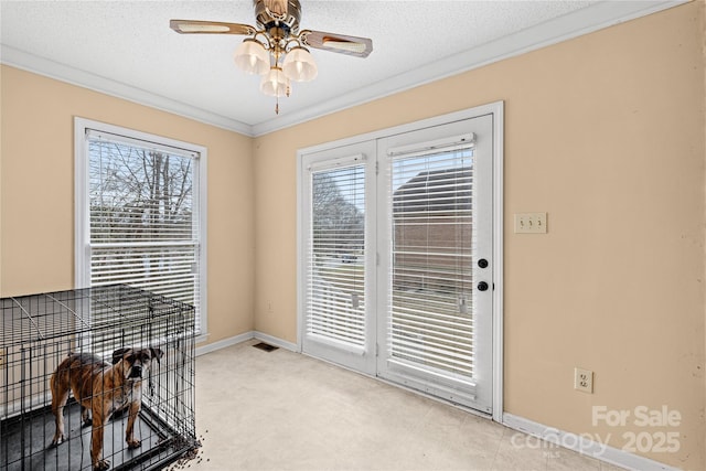 doorway with ornamental molding, a textured ceiling, ceiling fan, and a wealth of natural light