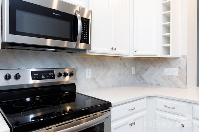 kitchen with tasteful backsplash, stainless steel appliances, and white cabinetry