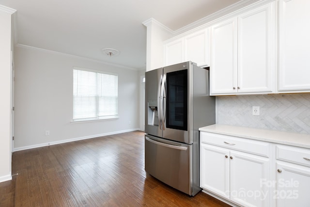 kitchen with white cabinets, stainless steel refrigerator, and crown molding