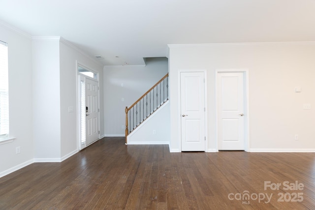 entryway with dark wood-type flooring and ornamental molding