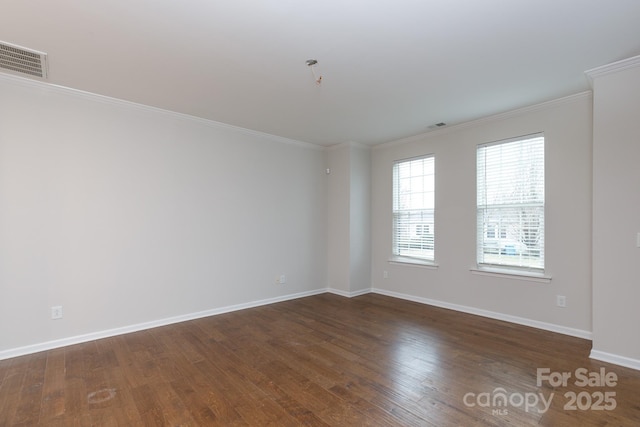 spare room featuring dark wood-type flooring and ornamental molding