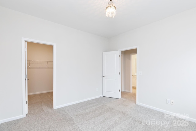 unfurnished bedroom featuring light carpet, a closet, and a walk in closet