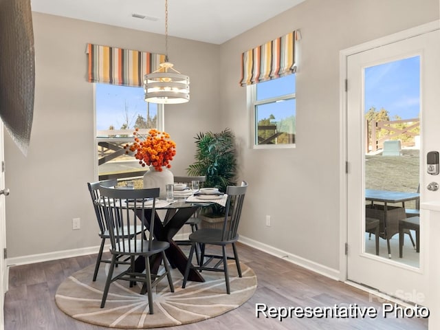 dining room with wood-type flooring and a chandelier