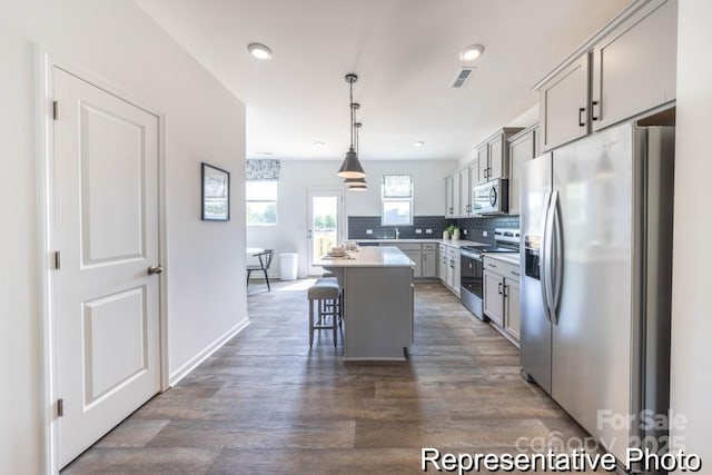 205 Cliffwood St NW Unit Unitb-2, Concord, NC 28027 - kitchen with appliances with stainless steel finishes, gray cabinets, dark wood-type flooring, a kitchen bar, and backsplash