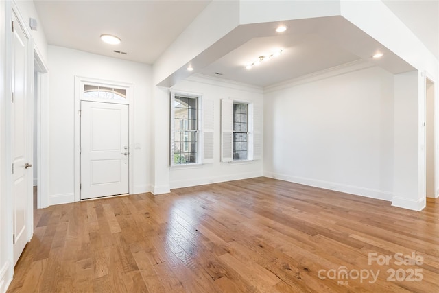 entrance foyer with light wood-style floors, visible vents, baseboards, and ornamental molding