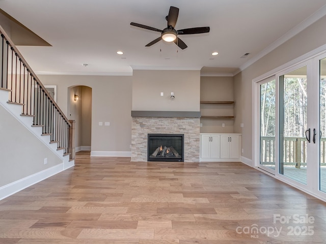 unfurnished living room with light wood-style floors, visible vents, baseboards, and crown molding