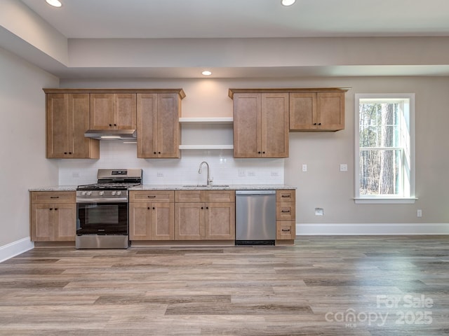 kitchen featuring open shelves, backsplash, appliances with stainless steel finishes, a sink, and under cabinet range hood