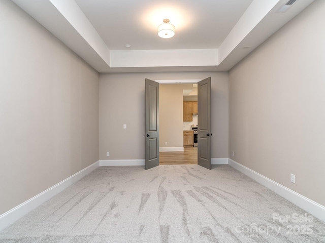 unfurnished bedroom featuring light carpet, visible vents, and baseboards