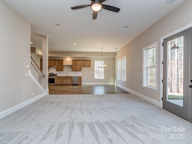 unfurnished living room with carpet, a sink, baseboards, and recessed lighting