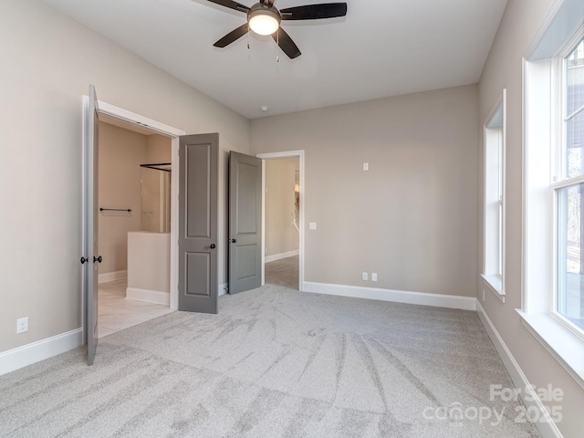 unfurnished bedroom featuring ensuite bathroom, carpet flooring, and baseboards