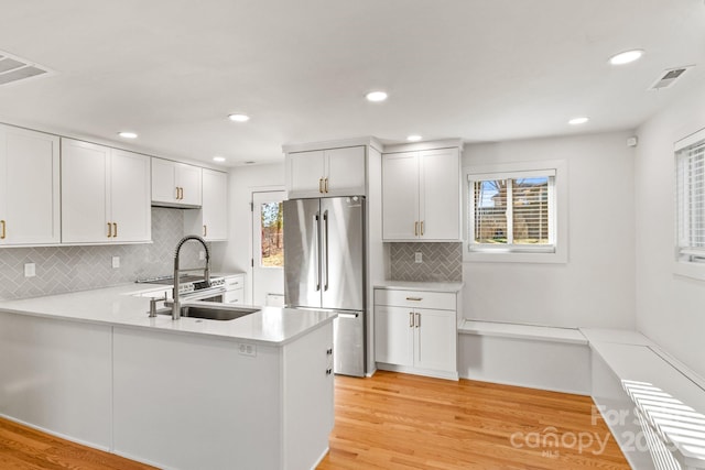 453 Riverview Dr, Asheville, NC 28806 - kitchen featuring stainless steel refrigerator, backsplash, kitchen peninsula, and white cabinets