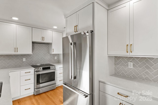 453 Riverview Dr, Asheville, NC 28806 - kitchen with tasteful backsplash, light wood-type flooring, white cabinets, and appliances with stainless steel finishes