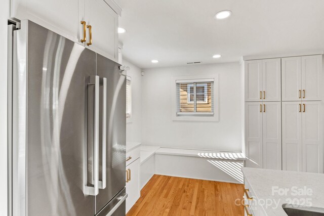 453 Riverview Dr, Asheville, NC 28806 - kitchen with high quality fridge, white cabinets, and light wood-type flooring