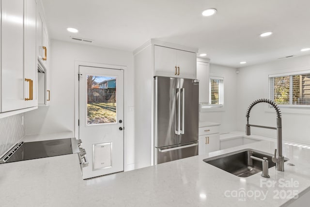 453 Riverview Dr, Asheville, NC 28806 - kitchen with high end fridge, sink, light stone countertops, and white cabinets