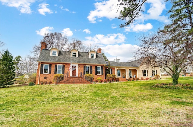 view of front of home with brick siding, a chimney, and a front yard