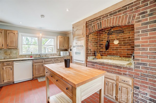 kitchen with a sink, white appliances, butcher block counters, crown molding, and decorative backsplash