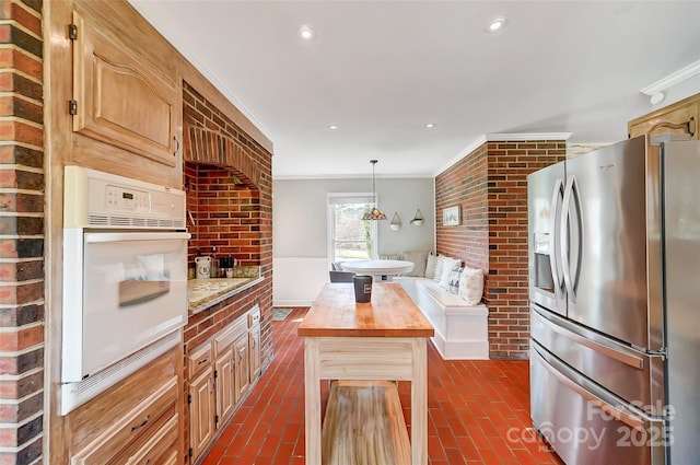 kitchen with white appliances, recessed lighting, brick floor, wood counters, and crown molding