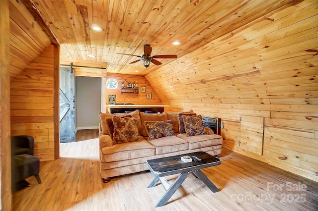 living area with wood finished floors, a barn door, wood walls, wood ceiling, and vaulted ceiling