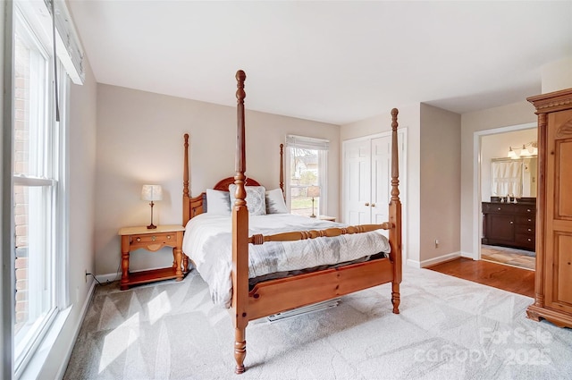 bedroom featuring carpet flooring, baseboards, a closet, and connected bathroom