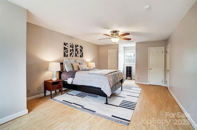 bedroom with light wood-style flooring, a ceiling fan, and baseboards