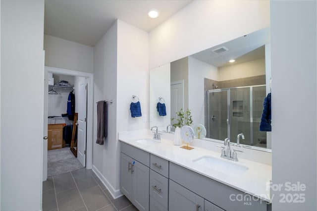 bathroom featuring vanity, tile patterned flooring, and a shower with door