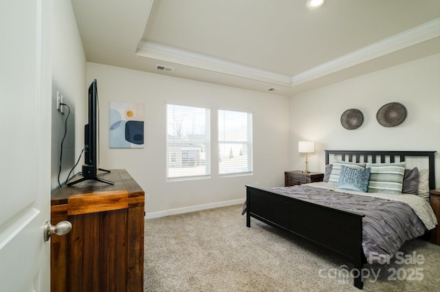 carpeted bedroom with a tray ceiling and ornamental molding