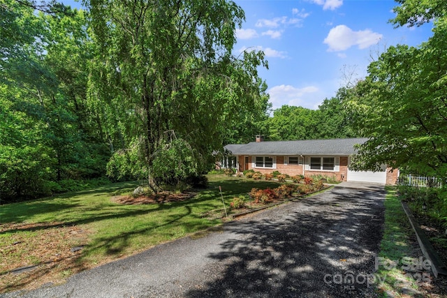 single story home with a front yard and a garage