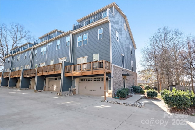 back of property featuring a garage and a wooden deck