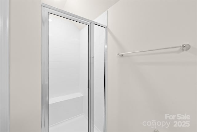 bathroom featuring a shower with door