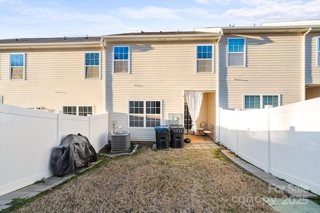 rear view of property featuring central AC, a yard, and a patio