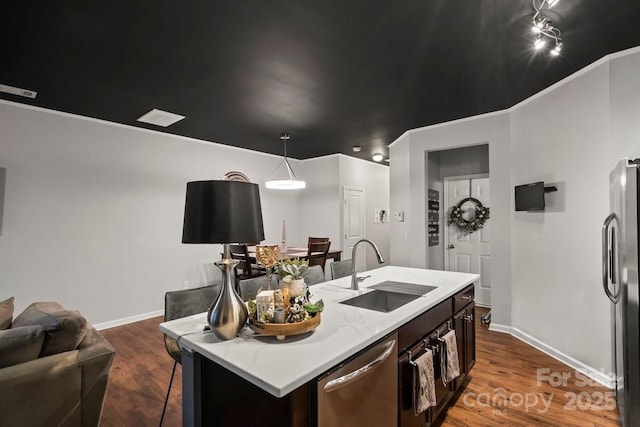 kitchen with sink, hardwood / wood-style floors, appliances with stainless steel finishes, and a kitchen island with sink