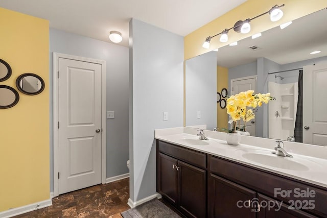 bathroom featuring walk in shower, vanity, and toilet