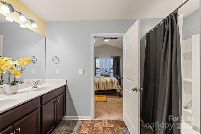 bathroom featuring ceiling fan, vanity, and vaulted ceiling